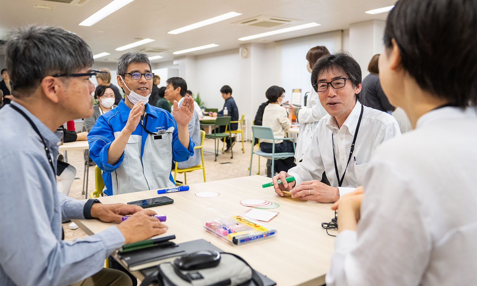 ４人の人がテーブルを囲んで対話する様子