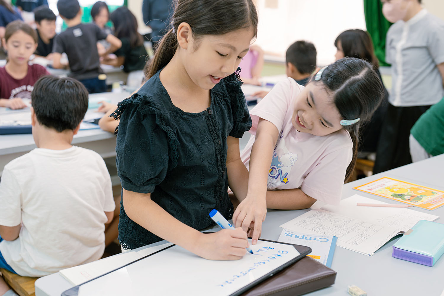 チームに別れ、ホワイトボードにノートの回収作戦を立てる子供達。